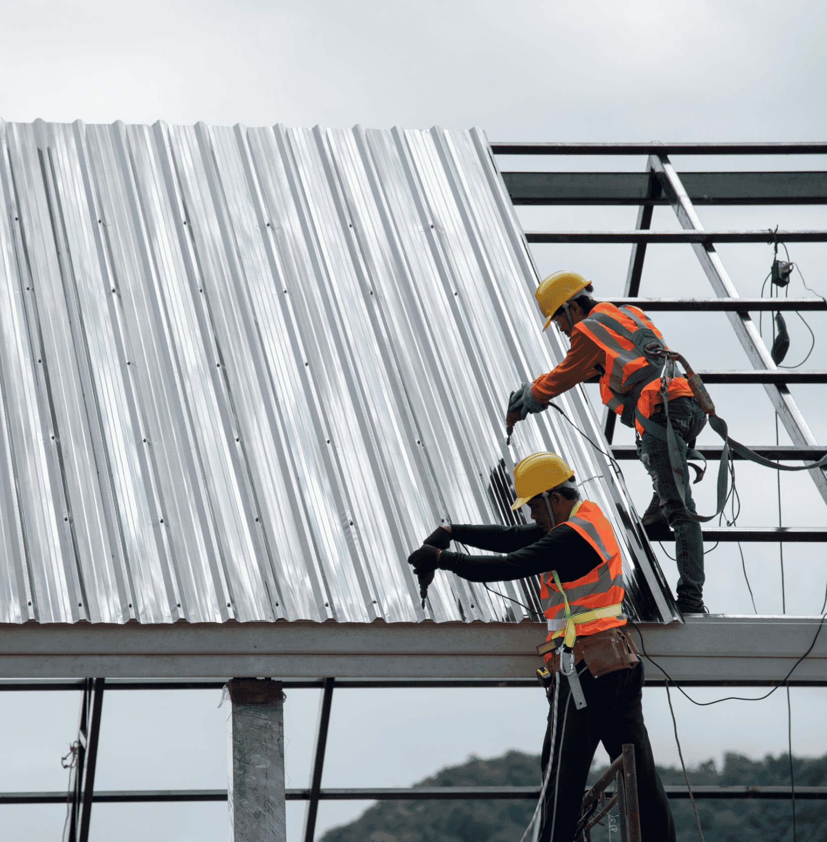Men setting up metal panel roofing